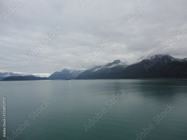 Fototapeta Mountain Filled horizon on the pacific ocean. Inside passage Alaska with glaciers at the peaks under a cloudy sky