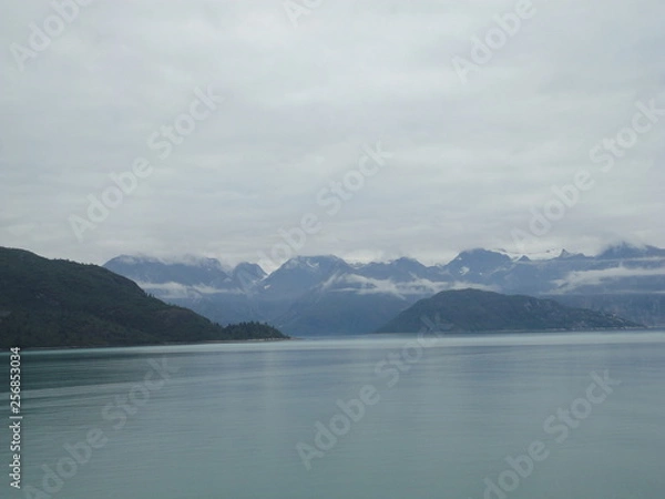 Fototapeta Mountain Filled horizon on the pacific ocean. Inside passage Alaska with glaciers at the peaks under a cloudy sky