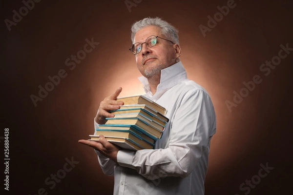 Obraz Scientific thinker, philosophy, elderly gray-haired man in a white shirt with a books, with studio light