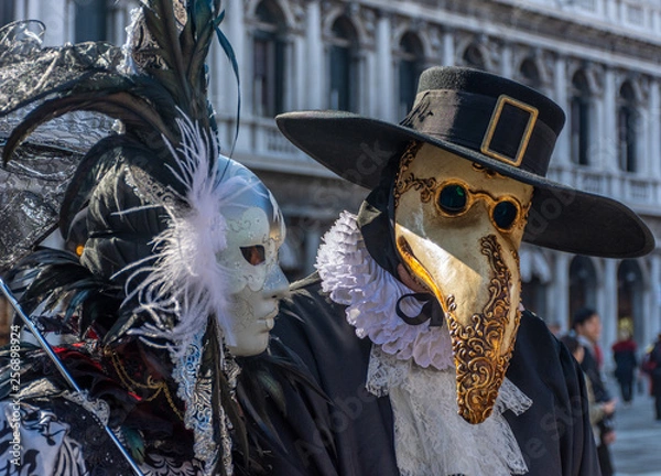 Fototapeta Italy, Venice, 2019, carnival, people with beautiful masks walk around Piazza San Marco, in the streets and canals of the city, posing for photographers and tourists, with colorful clothes.