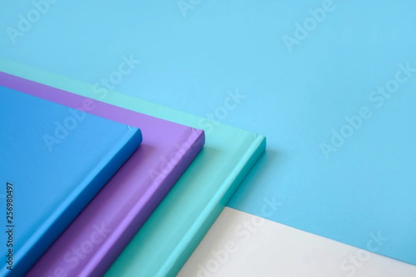 Fototapeta stack of multicolored books on a neutral background