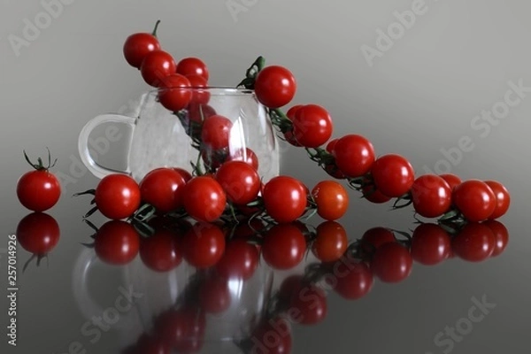 Fototapeta A branch of ripe red cherry tomatoes lying on the table