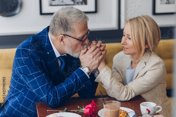 Fototapeta loving man kissing his woman's hands and showing his feeling and love. man thanking his wife for happy life. close up photo. ideal relationship between woman and man. smart man asking forgiveness