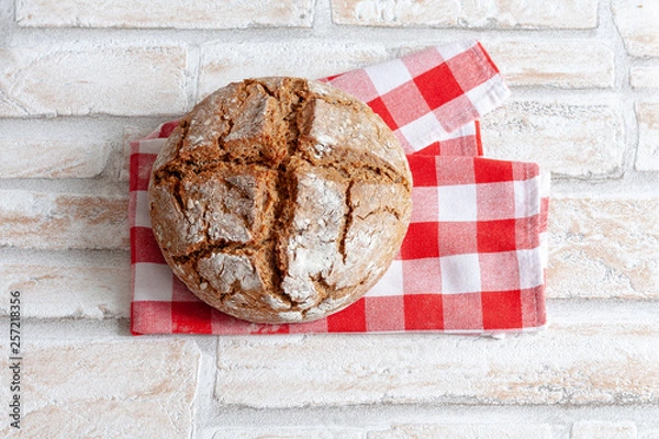 Fototapeta Farmers bread with a cross cut