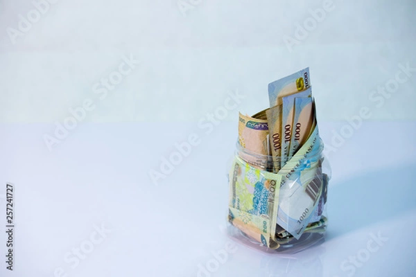 Fototapeta Naira notes in a glass jar - concept of Saving