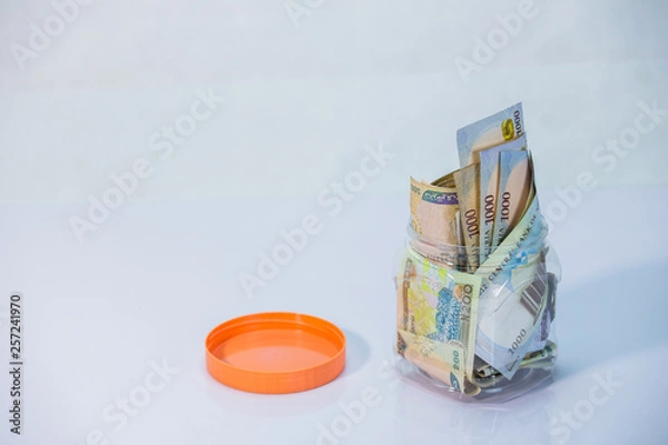 Fototapeta Naira notes in a glass jar - concept of Saving