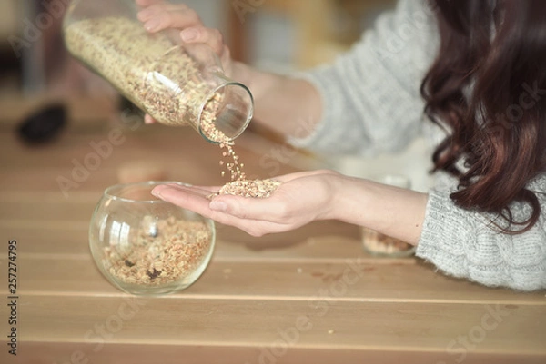 Fototapeta Young girl sitting at a table in a kitchen