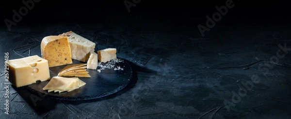 Fototapeta Different kinds of cheese on dark background, copy space