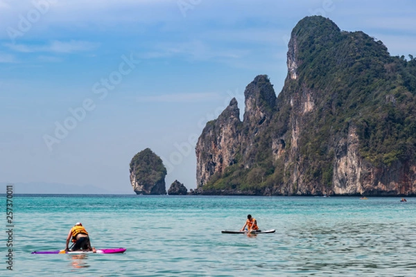 Fototapeta Two mans kayaking on the andaman sea near tropical Phi Phi islands . Sunny day and aquamarine water.