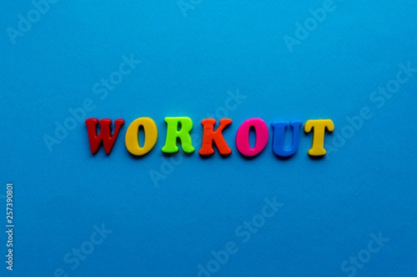 Obraz text workout  from plastic colored letters on blue paper background