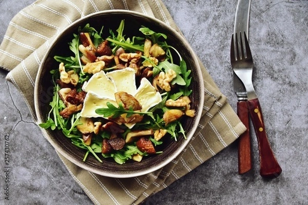 Fototapeta Mushrooms, dried figs and walnut salad with brie cheese. Top view salad isolated