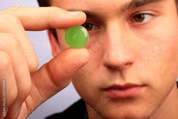 Obraz Mann mit Halsschmerztablette in der Hand