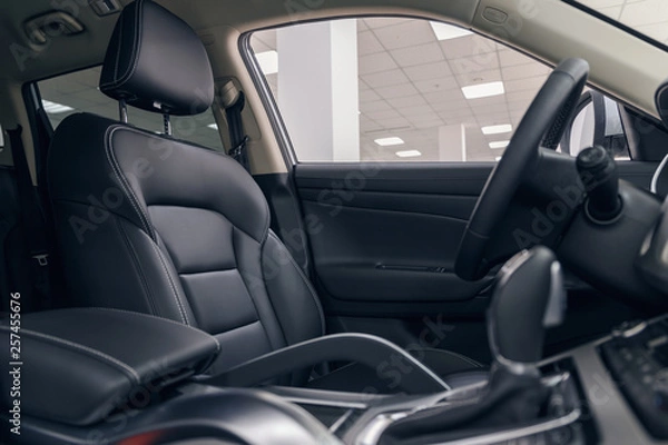 Fototapeta Leather car interior. Modern car illuminated dashboard. Luxurious car instrument cluster. Close up shot of automobile instrument panel. Modern car interior dashboard and steering wheel