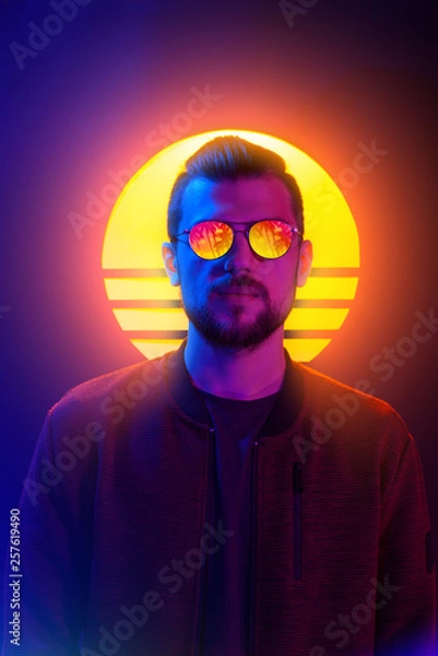 Fototapeta Sci-fi futurystyczny plakat mody w stylu lat 80-tych fioletowy neon. Retro fala synth pary fala portret młodego mężczyzny w okularach przeciwsłonecznych.