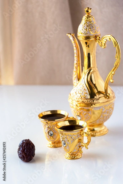 Obraz Still life with traditional golden arabic coffee set with dallah and cup. White background. Ramadan concept.
