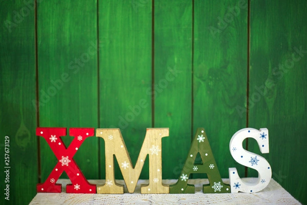 Fototapeta Colored wooden letters on the table forming the word XMAS