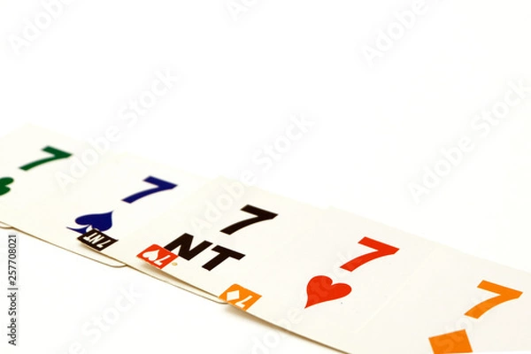 Fototapeta Bridge cards with 7 different suits on a white background. Equipment for a sports game of bridge. Betting concept.