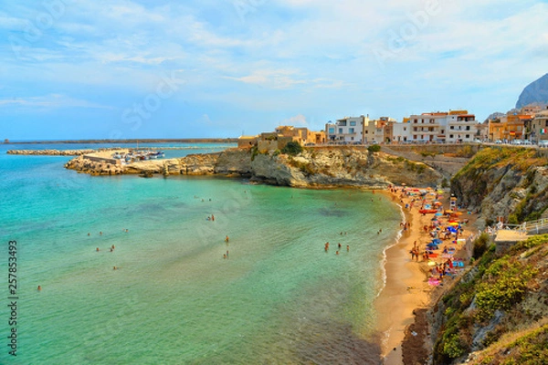 Fototapeta beautiful landscape in small coastal town Terrasini with beach calarossa with Faraglioni di Praiola with turquoise blue water and cloudy blue sky  in background, Sicily Italy Palermo