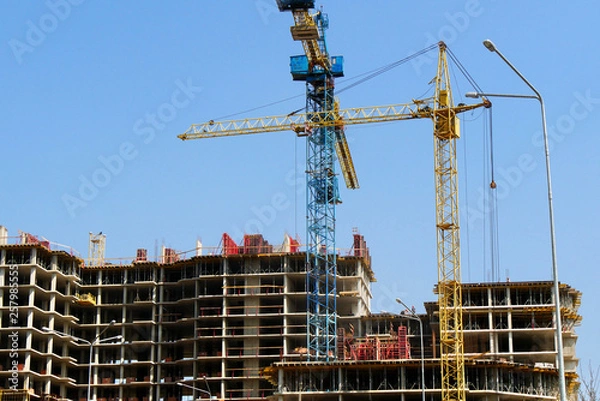Fototapeta Construction site background. Hoisting cranes and new multi-storey buildings. I.ndustrial background.