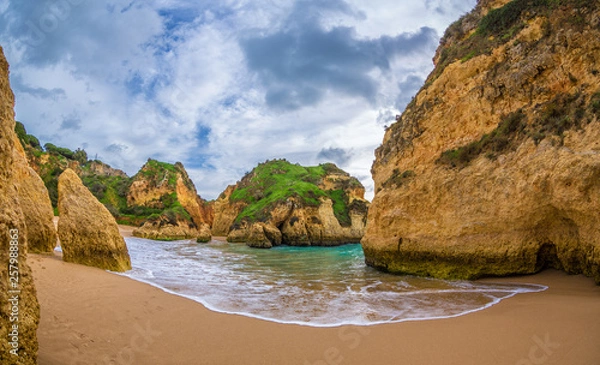 Obraz Famous rock formation in a bay on the beach of Tres Irmaos in Alvor, Portimão, Algarve, Portugal, Europe. Praia dos Tres Irmaos. View between two rocks.