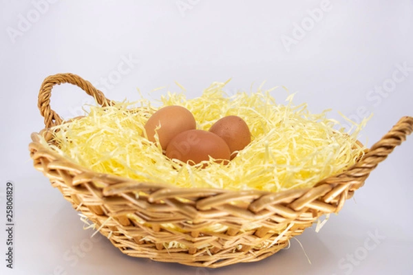 Fototapeta Oeufs bio de la ferme dans un panier en osier rempli de paille