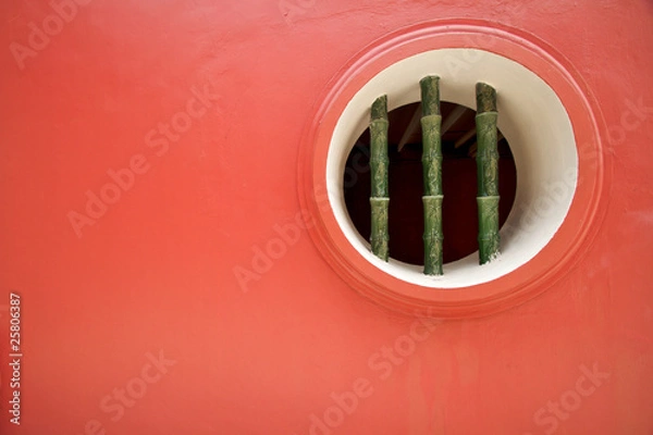 Fototapeta Solid red wall with bamboo window feature