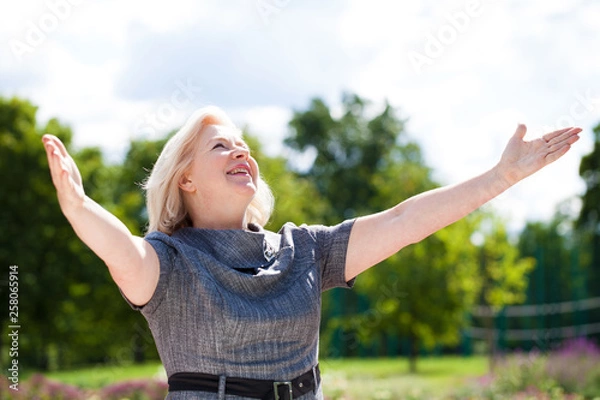 Fototapeta Happy elderly woman on the background of summer park