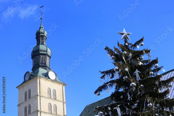 Fototapeta Sapin de Noël devant l'église Saint-Jean-Baptiste. Megève. / Christmas Tree in front of St. John the Baptist Church. Megève. 