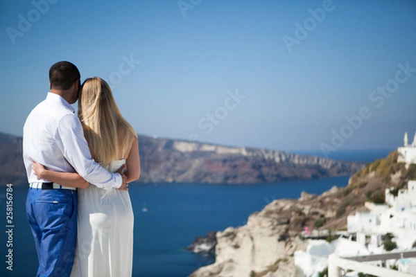 Fototapeta young couple pregnant on the most romantic island Santorini, Greece