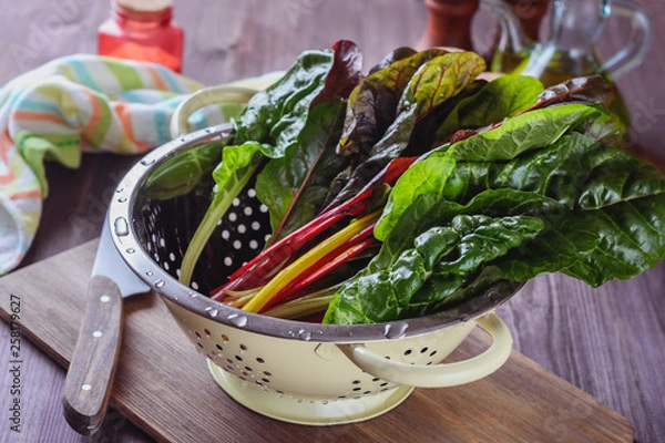 Fototapeta A lot of colorful eaves of chard are drained in a colander after has been rinsed in cold water to prepare salad with others ingridients