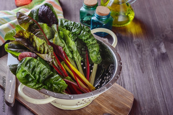 Fototapeta A lot of colorful eaves of chard are drained in a colander after has been rinsed in cold water to prepare salad with others ingridients
