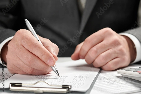 Fototapeta Businessman working in an office. Hands and documents closeup.