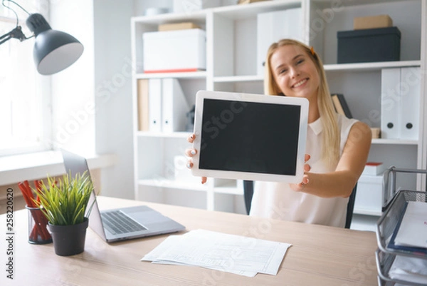 Obraz young beautiful woman work on tablet hold show screen sit at table in office smile