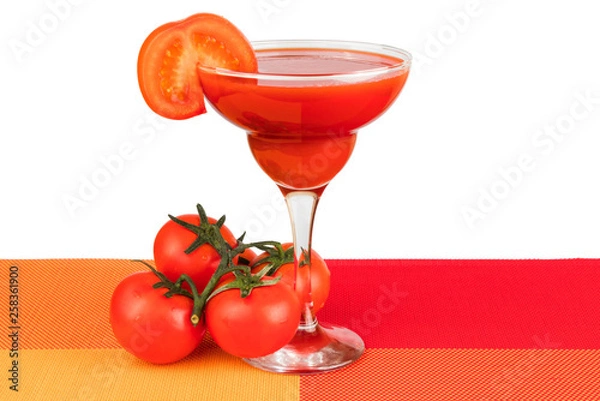 Fototapeta A glass with tomato juice with a slice of tomato on white isolated background