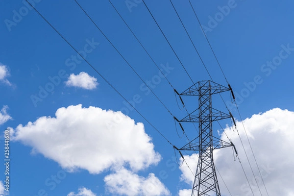 Obraz Large high tension power lines with cables and structures showing on a parlty cloudy and sunny day with blue skies