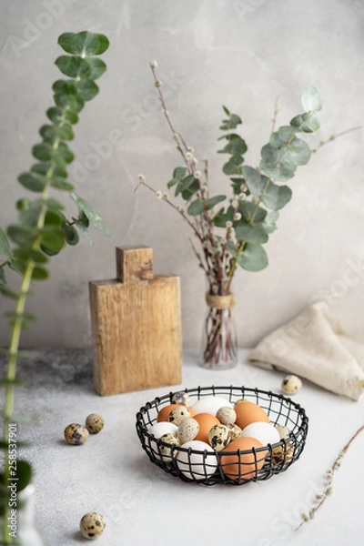 Obraz Easter background with eggs decorated with eucalyptus and willow branches.