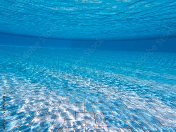 Obraz Transparent clear water in the pool. Underwater photo of the regulatory pool. Blue water pool bottom background. Summer theme.