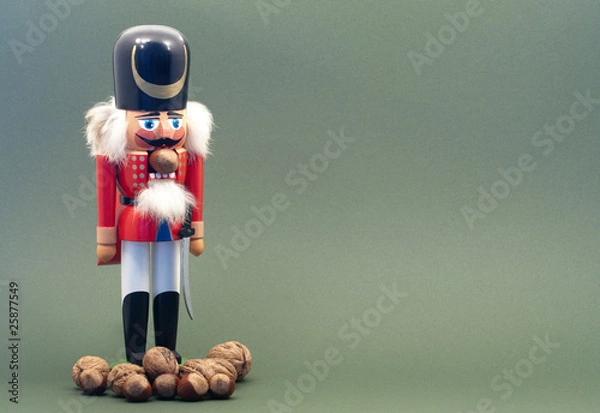 Obraz Wooden Nutcracker with Nuts Isolated on a Green Background.