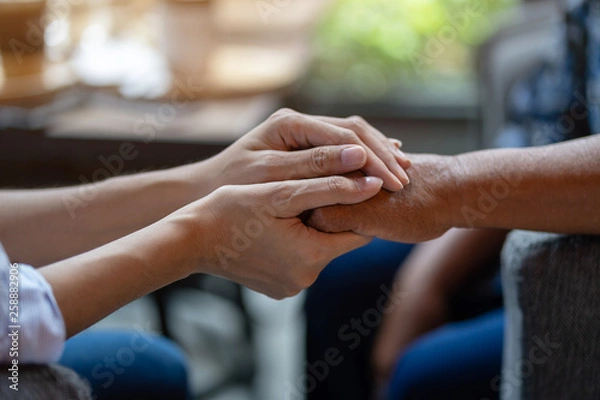 Obraz Hand of younger woman holding hand elderly woman, Helping hands, Take care for the elderly concept.