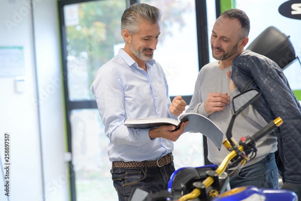 Obraz Salesman with client in bike shop