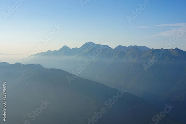 Fototapeta High mountain ranges in the haze. Journey towards fresh air.
