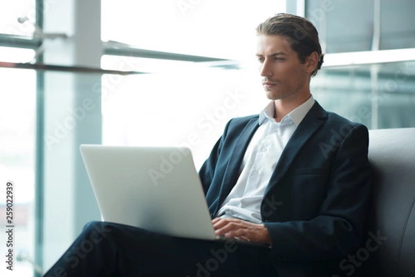 Fototapeta Adult serious man has business conversations using on-line mobile application. Developer innovational business web applications in the internet. Stylish guy. Business portrait. Cloud technologies.