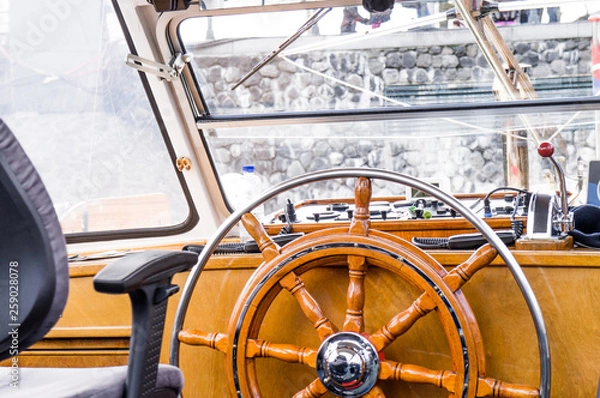Obraz Steering wheel or helm cabin view of a holiday cruiser boat in wooden style 