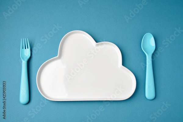 Obraz Blue plastic dishes and white plate on blue background. Concept