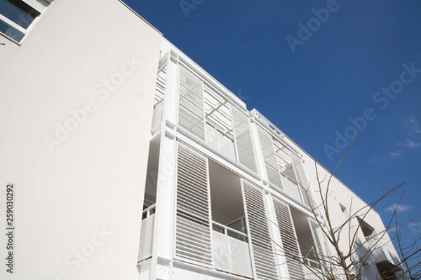 Fototapeta New multi-family block with balconies and bright on blue sky