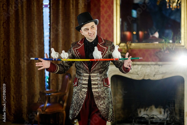 Fototapeta magician holds on forgive pigeons. The trainer of pigeons. Magic performance with pigeons