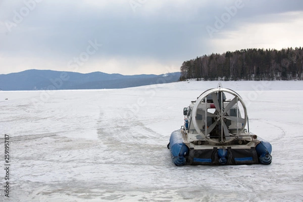 Obraz Hovercraft transporter on the ice of river in winter day