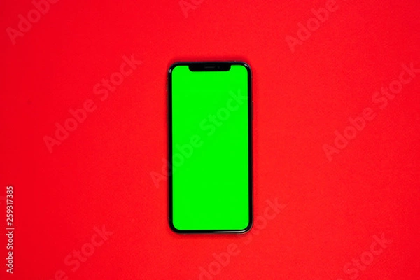 Fototapeta iPhone XS, smartphone, green screen on Red background top view