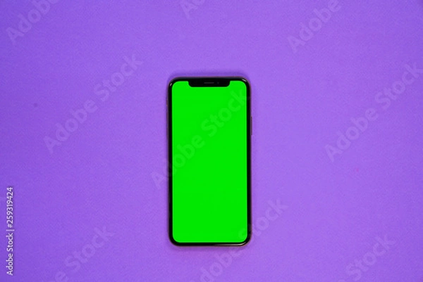 Fototapeta iPhone XS, smartphone, green screen on Violet background top view