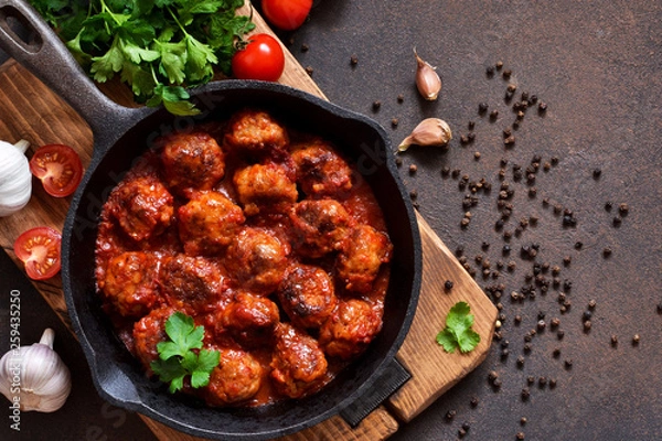 Fototapeta Meatballs in sweet and sour tomato sauce on the kitchen table. Top view